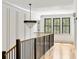 Hallway with elegant chandelier, hardwood floors, paneled walls, and natural light at 8187 Jack Island Dr, Johns Island, SC 29455