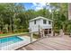 Backyard view of a modern pool and pool house surrounded by lush landscaping at 8187 Jack Island Dr, Johns Island, SC 29455