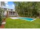 A modern pool is surrounded by lush greenery and mature trees, creating a private oasis at 8187 Jack Island Dr, Johns Island, SC 29455