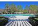 A full view of the community pool, with lounge chairs, a pergola, and greenery at 8618 Woodland Walk, North Charleston, SC 29420