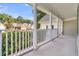 Covered porch with white columns and railing, offering a serene outdoor space at 8618 Woodland Walk, North Charleston, SC 29420
