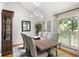 Elegant dining room featuring a chandelier, large windows, and a wooden table with comfortable seating at 914 Red Coat Run, Mount Pleasant, SC 29464