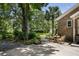 Charming brick home featuring a concrete patio with outdoor seating and lush landscaping and mature trees at 914 Red Coat Run, Mount Pleasant, SC 29464