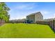 Spacious backyard with lush green grass, fenced perimeter, and the home's screened porch at 9808 Wooden Pestle Way, Ladson, SC 29456