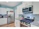 Modern kitchen featuring stainless steel appliances, granite countertops, and white cabinetry at 9808 Wooden Pestle Way, Ladson, SC 29456