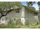 Exterior angle of the home showing vinyl and shingle siding, garage, and overgrown landscaping at 1014 E Cooper Ave, Folly Beach, SC 29439