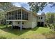 Exterior view of a raised home featuring a screened porch and mature landscaping at 1014 E Cooper Ave, Folly Beach, SC 29439