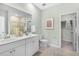 Bright bathroom featuring double sinks, light tile, and door to the walk-in closet at 1035 Tea Time Dr, Summerville, SC 29485