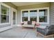 Covered patio featuring wicker furniture, neutral outdoor rug, and gray vinyl siding at 1035 Tea Time Dr, Summerville, SC 29485