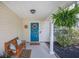 Cozy front porch with a wooden bench, potted plants, decorative wreath on a blue door at 105 Lovette Ct, Goose Creek, SC 29445