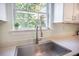 Close up of kitchen sink with modern faucet, bright window and white countertop at 105 Lovette Ct, Goose Creek, SC 29445