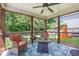 Cozy screened porch with chairs and table, with backyard view of play set and green lawn at 105 Lovette Ct, Goose Creek, SC 29445