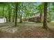 Spacious backyard with mature trees, a brick house, and a storage shed at 105 Spring St, Summerville, SC 29485