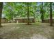 Large backyard featuring mature trees, an exterior view of the house, and a lush green lawn at 105 Spring St, Summerville, SC 29485