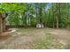 Large backyard with lush trees, grass, and a storage shed at 105 Spring St, Summerville, SC 29485