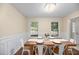 Dining area with wainscoting and hardwood flooring; a wood table, stylish chairs, and natural light at 105 Spring St, Summerville, SC 29485