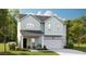 Charming two-story home featuring a light blue exterior, a two-car garage, and a cozy front porch at 115 Pen Shell St, Summerville, SC 29485