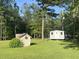 View of shed and outbuilding in a grassy, wooded backyard at 1173 Penny Creek Dr, Ruffin, SC 29475