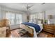 Light-filled bedroom boasts a wooden bed frame, stylish rug, and abundant natural light through large windows at 1466 Mizzen Aly, Johns Island, SC 29455