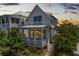 Charming two-story home featuring a welcoming porch, light blue shutters, and lush landscaping at 1466 Mizzen Aly, Johns Island, SC 29455
