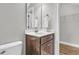 Bright bathroom with a wood vanity, gray walls, large mirror, and a door to the Primary closet at 1601 Bourne Xing, Mount Pleasant, SC 29466