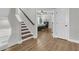 Welcoming hallway featuring modern wood flooring and staircase, leading to a glimpse of a well-appointed bedroom at 1601 Bourne Xing, Mount Pleasant, SC 29466