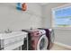 Functional laundry room featuring sink, washing machine, dryer, and storage shelves at 1601 Bourne Xing, Mount Pleasant, SC 29466