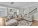 Comfortable living room featuring a large sectional sofa, decorative rug, and open views to the kitchen and staircase at 1601 Bourne Xing, Mount Pleasant, SC 29466