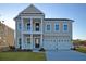 Two-story home with a lawn featuring white siding, white columns, and a two-car garage with a dark roof at 171 Threaded Fern Lndg, Summerville, SC 29485