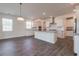 Bright kitchen features white cabinets, a large island, stainless steel appliances and hardwood floors at 175 Threaded Fern Lndg, Summerville, SC 29485