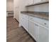 Spacious pantry with white cabinets, granite countertops and hardwood floors at 175 Threaded Fern Lndg, Summerville, SC 29485