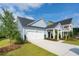 New construction home showcasing an attached garage, covered entry, and professionally landscaped front yard at 1819 Nola Run, Summerville, SC 29485