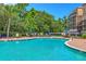 Relaxing outdoor pool area with plenty of seating surrounded by trees at 200 River Landing Dr # 307B, Charleston, SC 29492