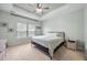 Calm bedroom with a tray ceiling, ceiling fan, natural light, and carpet flooring at 201 Maywood Dr, Moncks Corner, SC 29461