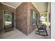 Cozy front porch with brick siding, two rocking chairs, and a welcome mat at 201 Maywood Dr, Moncks Corner, SC 29461