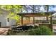 Landscaped backyard showcasing a charming pond feature and an outdoor cooking area beneath a pergola at 202 Woodbridge Dr, Summerville, SC 29486