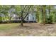 Charming home exterior with a covered front porch nestled among mature trees and a green lawn at 202 Woodbridge Dr, Summerville, SC 29486