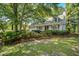 Charming home with a cozy front porch, lush landscaping, and mature trees in a well-maintained yard at 202 Woodbridge Dr, Summerville, SC 29486