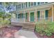Inviting front porch with brick steps, white railing, green door, and lush landscaping at 303 High Grove Rd, Summerville, SC 29485