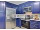 Close up view of stainless steel appliances and blue cabinets in the updated kitchen at 303 High Grove Rd, Summerville, SC 29485