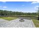 A backyard featuring a stone fire pit, lush grass, and a peaceful view of the lake at 316 Beachgrass Ln, Summerville, SC 29486