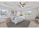 This staged bedroom features large windows, tray ceilings, fan, and decorative wall art at 316 Beachgrass Ln, Summerville, SC 29486
