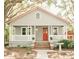 Charming single-story home featuring a cozy front porch, red door, and mature trees at 317 Bay St, Walterboro, SC 29488