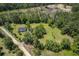 Aerial view of a beautiful home and yard near dirt road and forest under a sunny blue sky at 326 Turner Ln, Round O, SC 29474