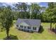 Aerial view of a charming white home surrounded by mature trees and a green lawn at 326 Turner Ln, Round O, SC 29474