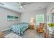 Bright bedroom features a ceiling fan, floral bedding, and a glimpse into an attached bathroom at 326 Turner Ln, Round O, SC 29474