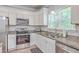 This modern kitchen is equipped with stainless steel appliances, granite counters, and white cabinetry at 326 Turner Ln, Round O, SC 29474