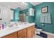 Bright bathroom with teal walls, wood vanity, double sinks, and a shower/tub with sliding doors at 3312 Telford Ct, Summerville, SC 29485