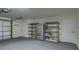 Organized garage with a refrigerator, shelving units, and a clean, gray carpeted floor at 4028 Babbitt St, Charleston, SC 29414