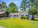Inviting single-story home with a lush green lawn, mature trees, and manicured shrubs in a desirable neighborhood at 405 Amberjack Way, Summerville, SC 29485